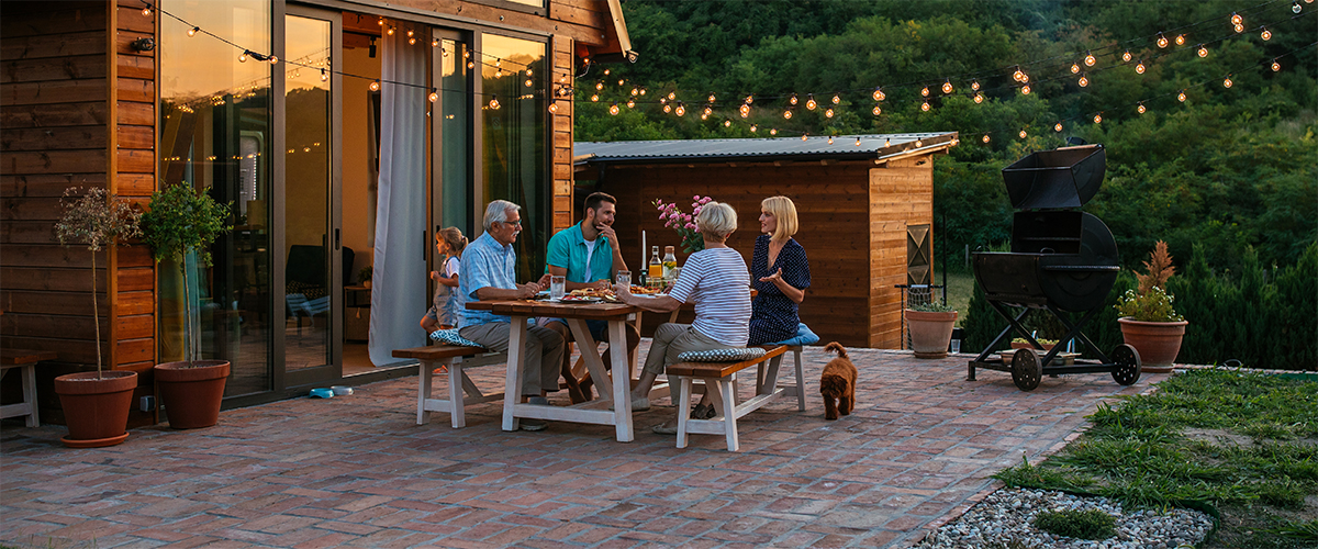 Vier Personen sitzen auf einer Terrasse, essen und unterhalten sich.
